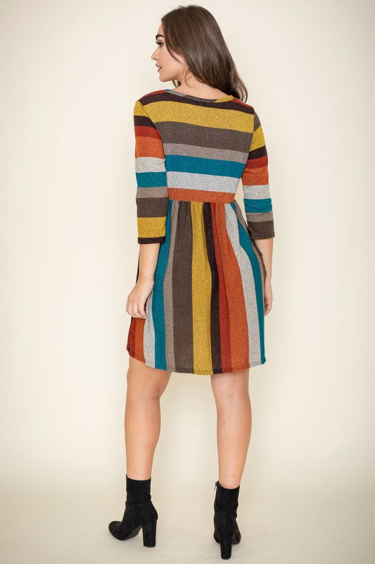 A woman is wearing the Multi Color Mini Dress, crafted from polyester spandex with long sleeves. She is looking off to the left. Made in the United States.