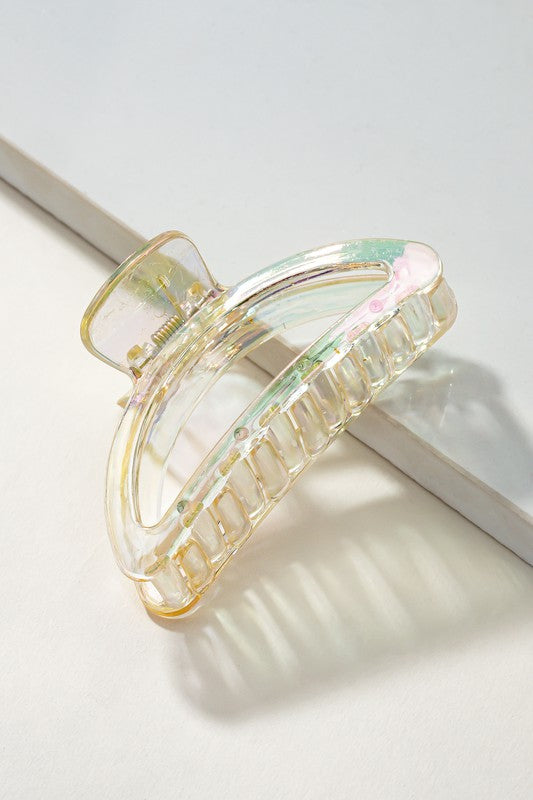 Five Iridescent Crescent Shape Big Claw Hair Clips, featuring the delicate tones of a Morandi color palette, are displayed on a beige surface with a white rectangular strip.