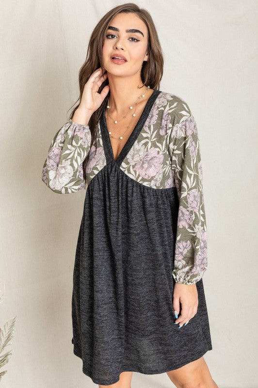 A woman wearing a Floral V Neck Boho Dress featuring floral patterned sleeves and standing against a neutral backdrop. Made in the United States, this outfit embodies timeless style and elegance.