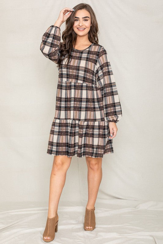 A woman smiling in a Plaid Balloon Sleeve Tiered Midi Dress, standing in front of a neutral background.