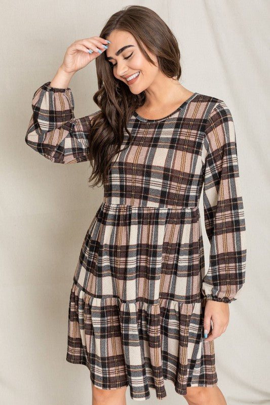 A woman smiling in a Plaid Balloon Sleeve Tiered Midi Dress, standing in front of a neutral background.