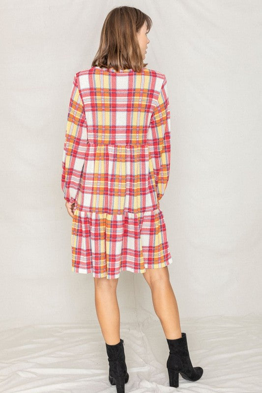 A woman smiling in a Plaid Balloon Sleeve Tiered Midi Dress, standing in front of a neutral background.