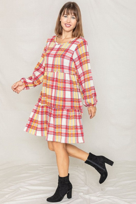 A woman smiling in a Plaid Balloon Sleeve Tiered Midi Dress, standing in front of a neutral background.