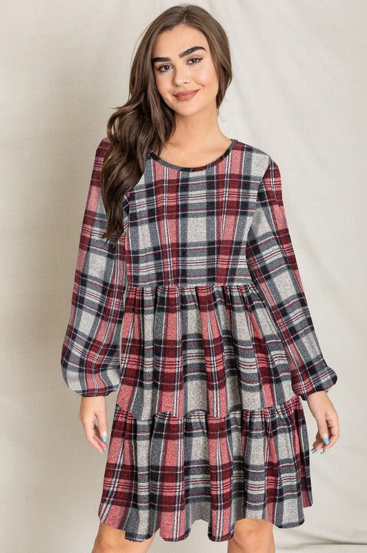 A woman smiling in a Plaid Balloon Sleeve Tiered Midi Dress, standing in front of a neutral background.