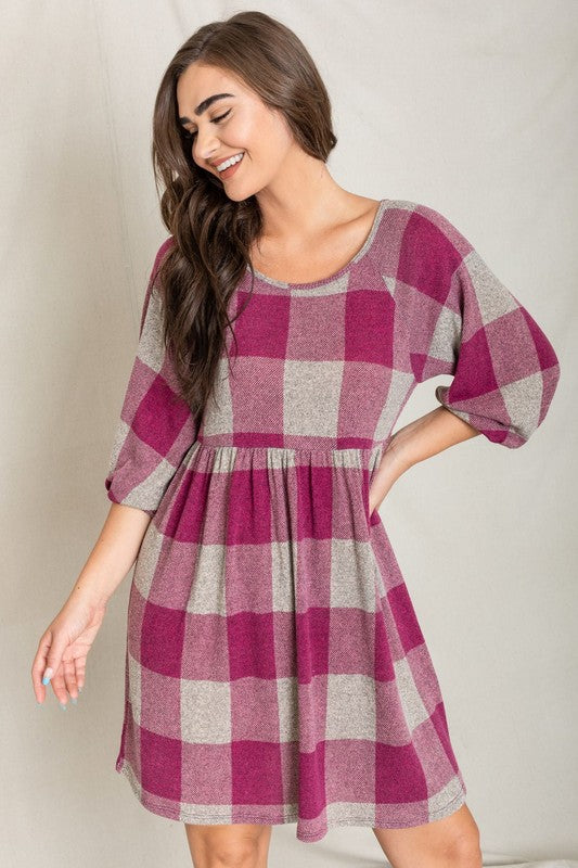 A person in a Checker Balloon Sleeve Midi Dress, featuring blue and gray checkered patterns and made of polyester, matched with tan ankle boots stands against a light background.