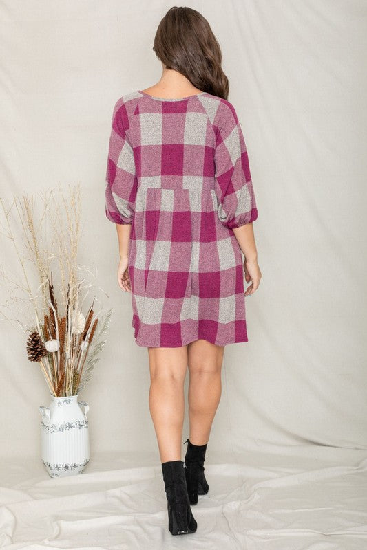 A person in a Checker Balloon Sleeve Midi Dress, featuring blue and gray checkered patterns and made of polyester, matched with tan ankle boots stands against a light background.