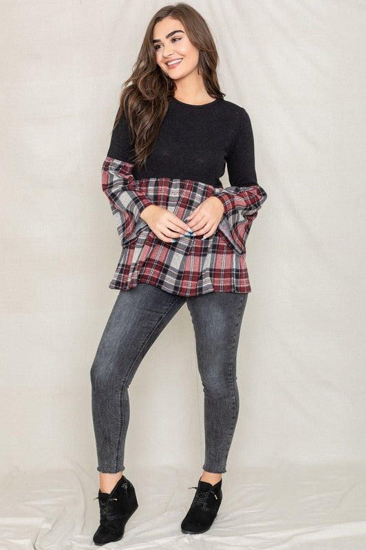 A person wearing the Bell Sleeve Plaid Tunic in gray polyester, featuring yellow plaid flares at the sleeves and bottom hem, is standing against a neutral background.