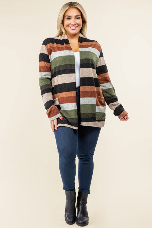 A person wearing the Plus Suede Elbow Patch Open Cardigan with Pockets, characterized by its multi-colored stripes, suede elbow patches, and dual front pockets, stands against a plain background over a white shirt and jeans.