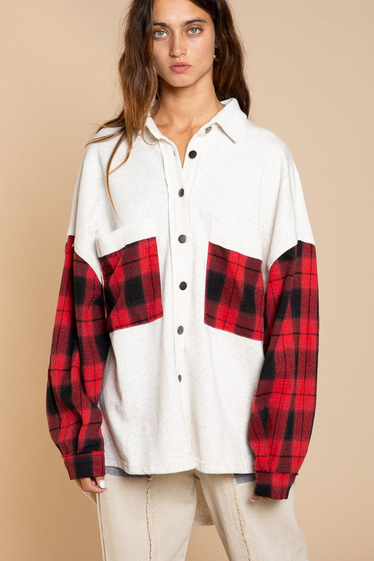 A person wearing the Long Sleeve With Plaid Detail Sleeve Shacket in brown, featuring plaid details on the sleeves and a matching pocket, paired with a white top underneath and a wide-brimmed hat—perfect for transitional weather.