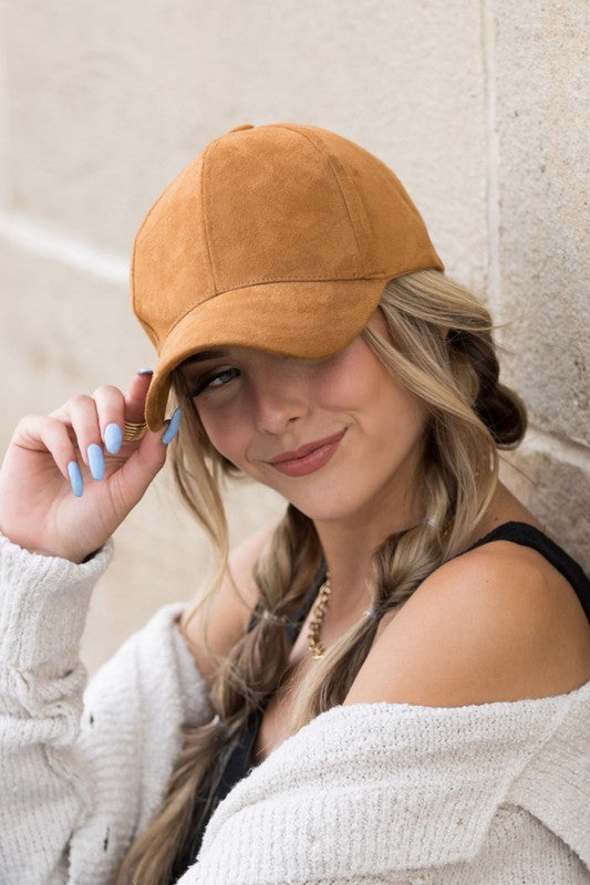 Woman smiling and leaning against a wall while wearing a Suede Boyfriend Ball Cap Hat.
