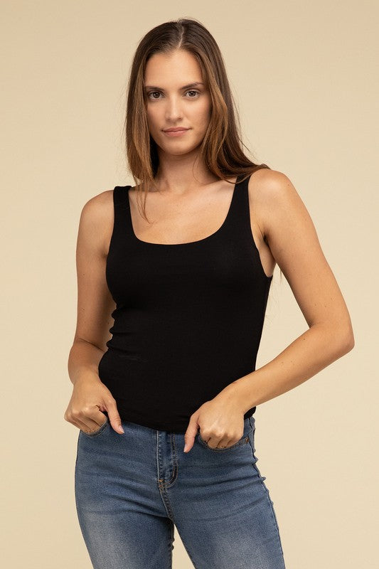 Dressed in a Double Layer Round Neck Tank Top and jeans, the person exudes stylish comfort while standing against a beige background.