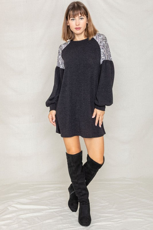 A woman stands smiling, wearing the Paisley Shoulder Accent Tunic Dress.