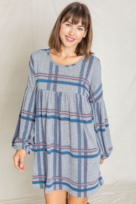 A woman wearing a Plaid Empire Waist Balloon Sleeve Mini Dress stands and smiles against a plain background.