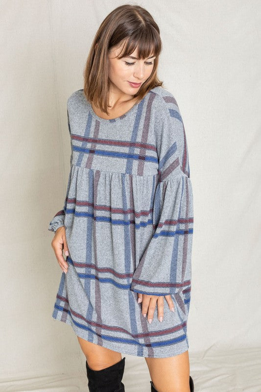 A woman wearing a Plaid Empire Waist Balloon Sleeve Mini Dress stands and smiles against a plain background.