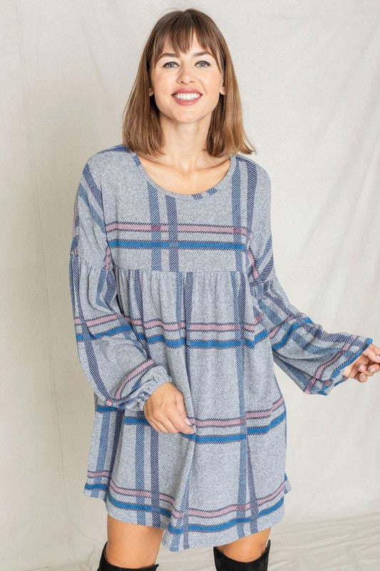 A woman in a Plaid Empire Waist Balloon Sleeve Mini Dress smiles and poses in front of a plain backdrop.