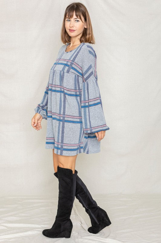 A woman wearing a Plaid Empire Waist Balloon Sleeve Mini Dress stands and smiles against a plain background.