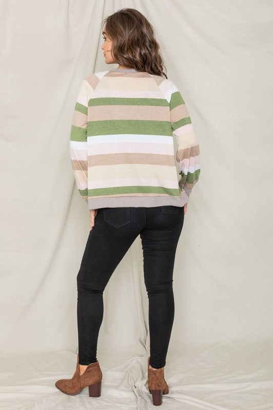 A person wearing the Multi Color Stripe Waffle Trim Open Cardigan over a green top and black pants stands against a light background.