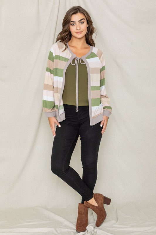 A person wearing the Multi Color Stripe Waffle Trim Open Cardigan over a green top and black pants stands against a light background.