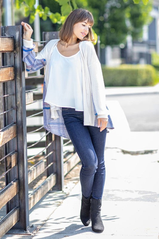 A woman models the Plaid Back Waffle Knit Cardigan paired with black pants, standing against a light background.