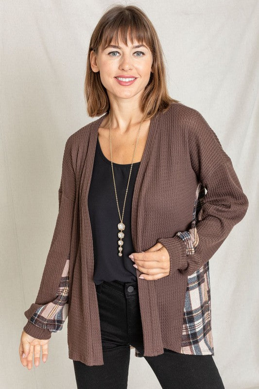 A woman models the Plaid Back Waffle Knit Cardigan paired with black pants, standing against a light background.