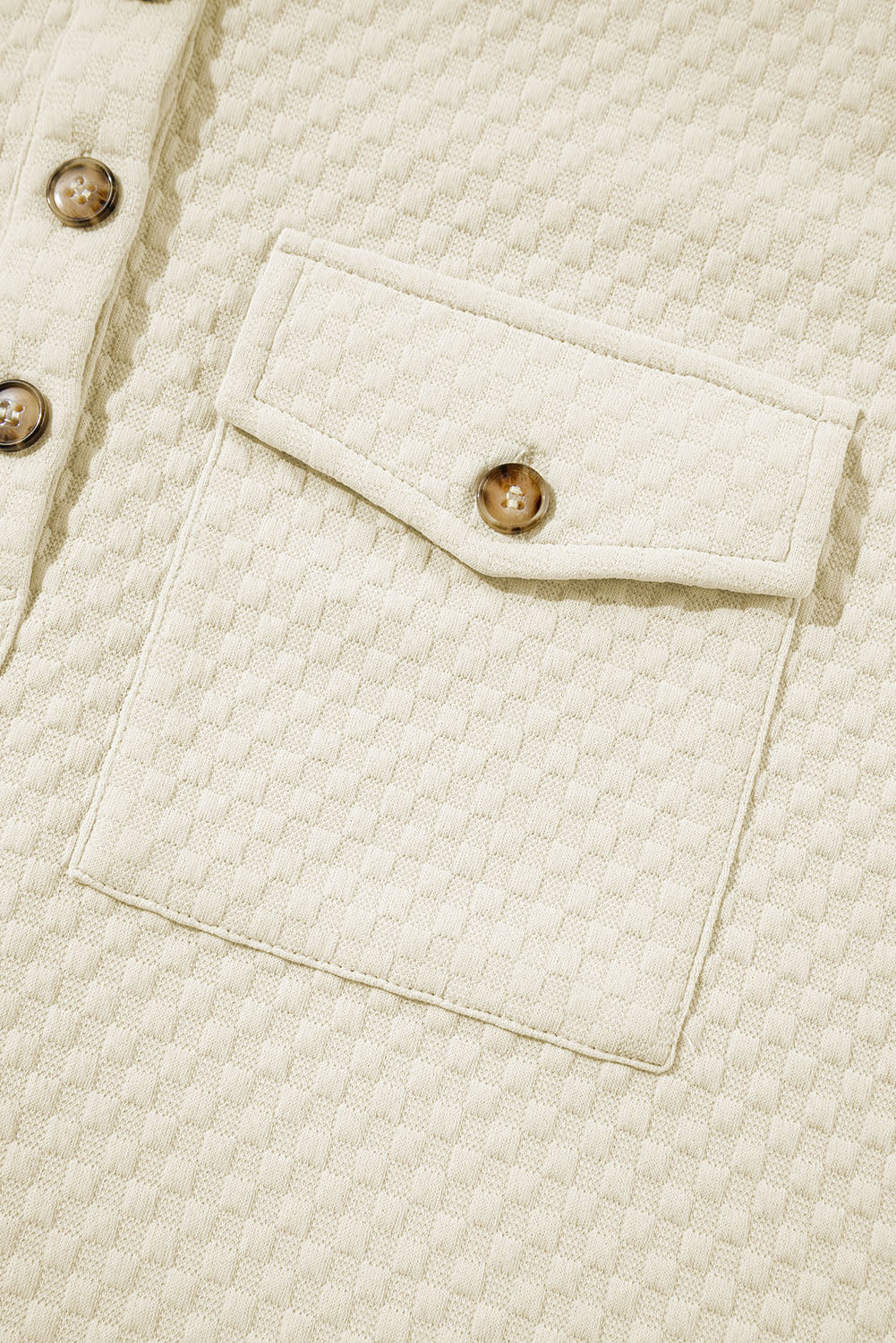 A person stands indoors facing away, wearing the Apricot Textured Buttoned Neckline Side Pockets Hoodie and black shorts. Their hand rests on their hip.