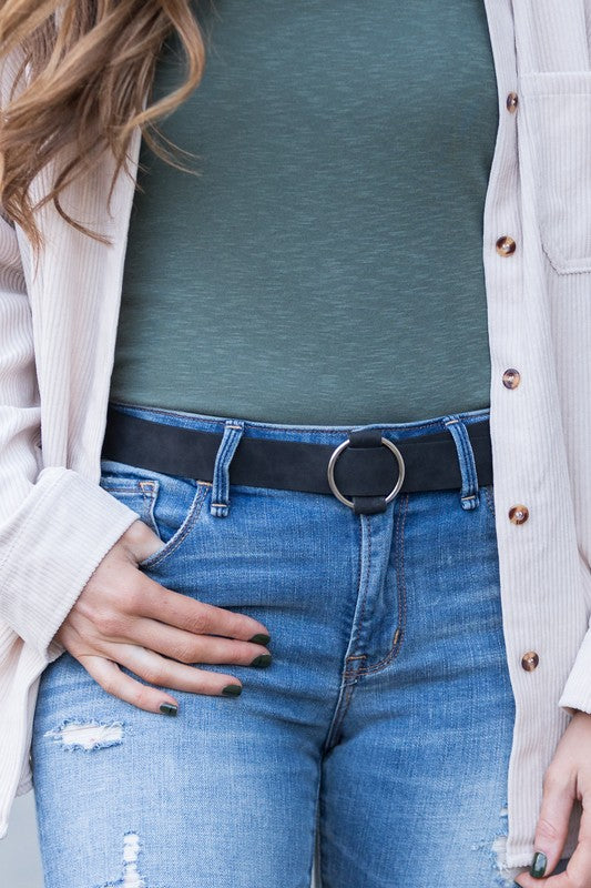 Woman wearing jeans with a brown O-Ring Belt, a white top, and a gray cardigan.