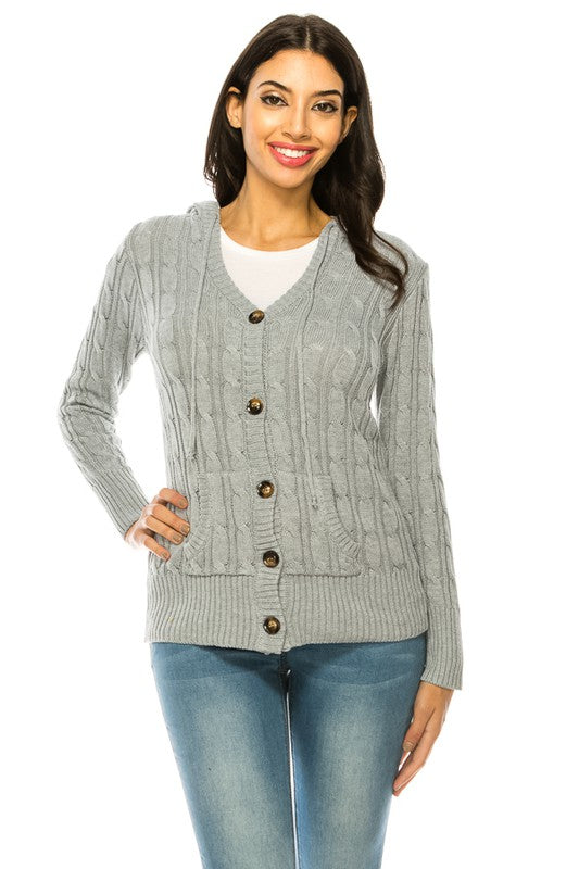 A woman in a Knit Sweater Button Front cardigan and blue jeans stands smiling with one hand on her hip against a white background.