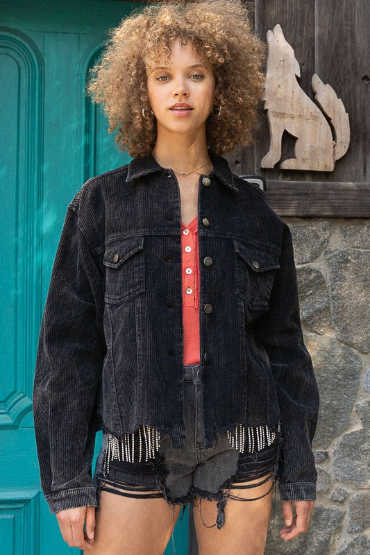 Woman wearing an oversized ribbed shacket with long sleeves and front pockets, exuding cozy comfort against a plain background.