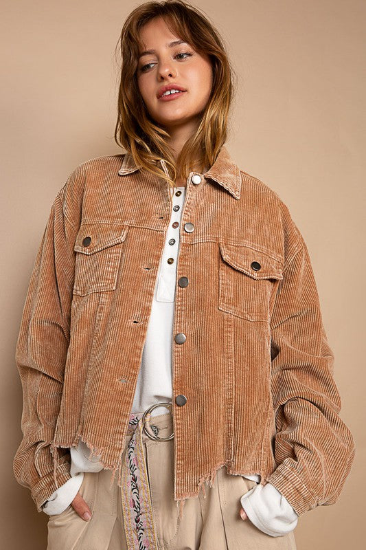 Woman wearing an oversized ribbed shacket with long sleeves and front pockets, exuding cozy comfort against a plain background.