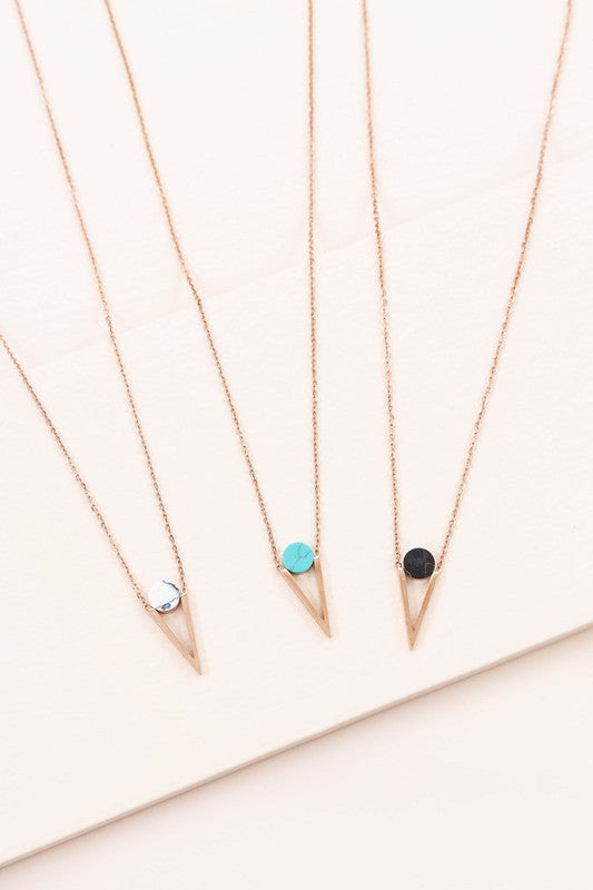 Three Tensly Point Stone Necklaces in rose gold boast a triangular charm pendant, each embellished with a natural stone available in white, turquoise, or black, elegantly displayed side by side.