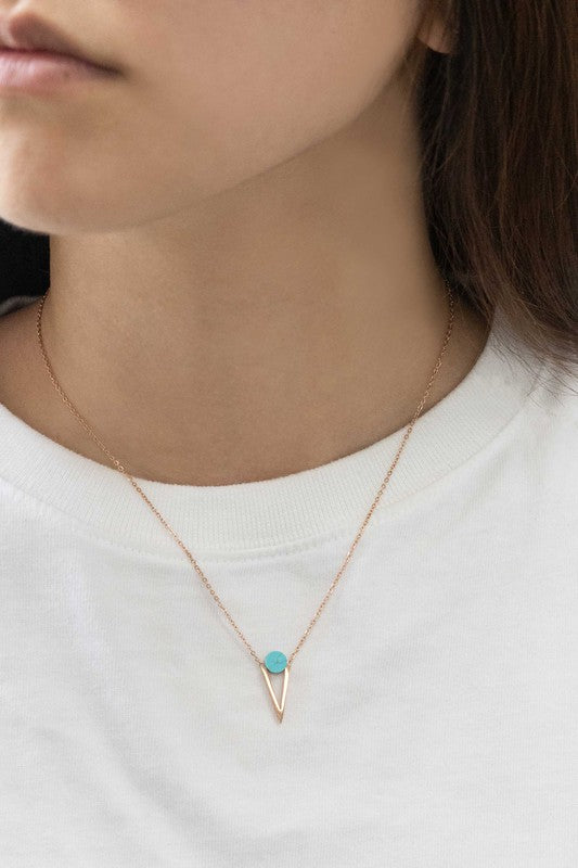 Three Tensly Point Stone Necklaces in rose gold boast a triangular charm pendant, each embellished with a natural stone available in white, turquoise, or black, elegantly displayed side by side.