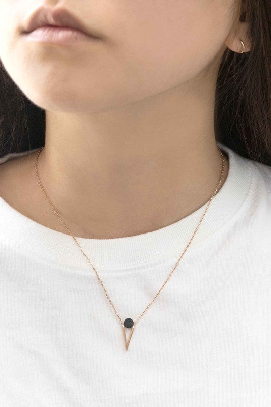 Three Tensly Point Stone Necklaces in rose gold boast a triangular charm pendant, each embellished with a natural stone available in white, turquoise, or black, elegantly displayed side by side.