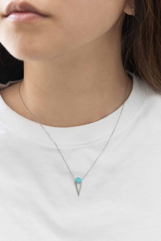 The Tensly Point Stone Necklace Silver collection features three charm necklaces with silver chains, each showcasing a triangular pendant enhanced by a circular accent in black, turquoise, and white. Displayed on a light background, these stainless steel pieces elegantly emphasize the allure of natural stones.