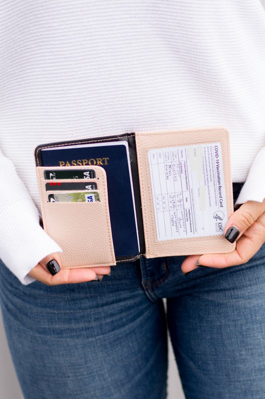 Person holding an open Passport and Vaccine Credit Card Wallet in leopard print vegan leather containing a passport, several cards, and a vaccine card holder.