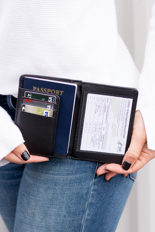 Person holding an open Passport and Vaccine Credit Card Wallet in leopard print vegan leather containing a passport, several cards, and a vaccine card holder.