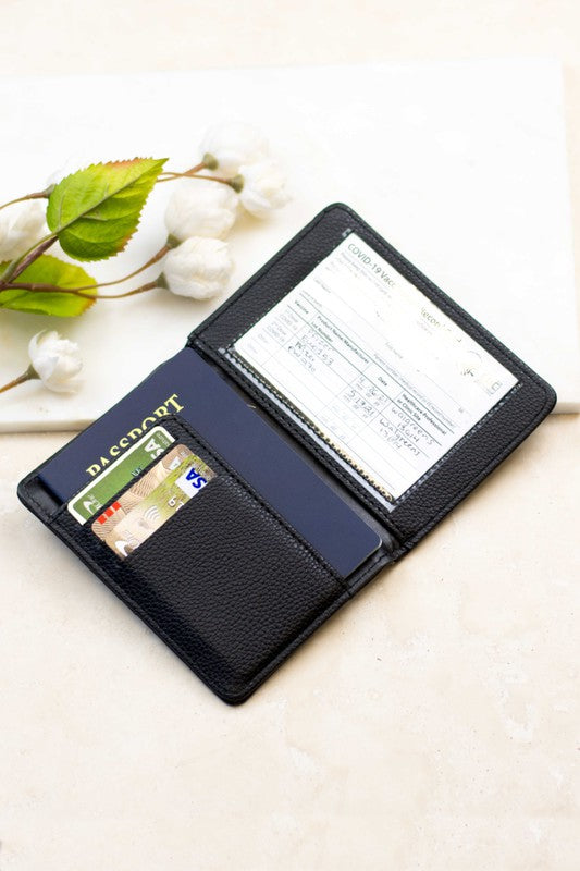 Person holding the Passport and Vaccine Credit Card Wallet made from stylish vegan leather with a leopard print, containing a passport, boarding pass, vaccine card holder, and several cards.