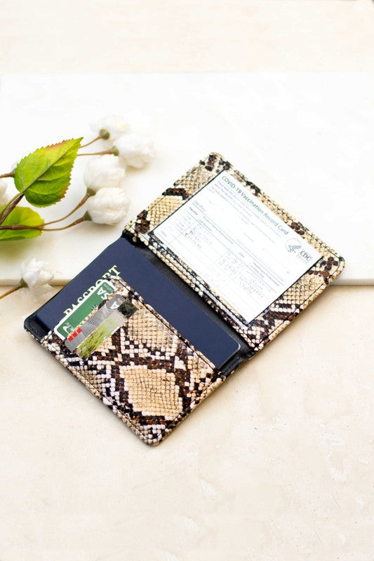 Person holding the Passport and Vaccine Credit Card Wallet made from stylish vegan leather with a leopard print, containing a passport, boarding pass, vaccine card holder, and several cards.