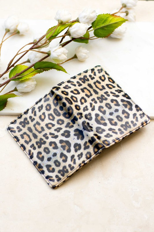 Person holding the Passport and Vaccine Credit Card Wallet made from stylish vegan leather with a leopard print, containing a passport, boarding pass, vaccine card holder, and several cards.