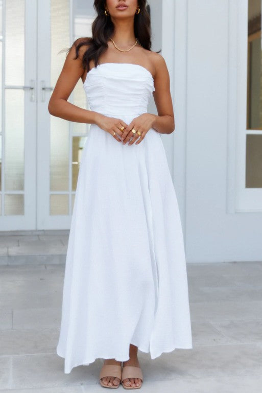 Dressed in the elegant Ruched Off-Shoulder Maxi Dress, featuring a thigh-high slit, a person stands gracefully indoors, ready for sophisticated evenings or special occasions.