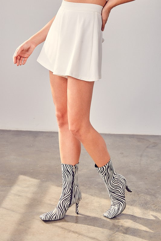 A person wearing white Flare Shorts that add a fashionable silhouette to their summer wardrobe.