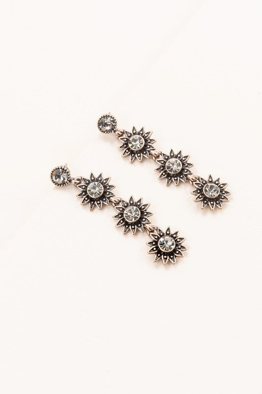 Sunflower Drop Earrings crafted from sterling silver, featuring star-shaped designs with black gem centers against a light background, ideal for formal jewelry occasions.