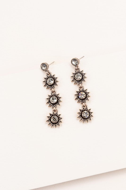 Sunflower Drop Earrings crafted from sterling silver, featuring star-shaped designs with black gem centers against a light background, ideal for formal jewelry occasions.