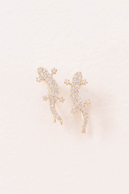 Three pairs of Lizard Ear Pin Earrings, featuring captivating stone-studded designs in gold, rose gold, and silver-plated brass jewelry, are elegantly presented on a light surface.