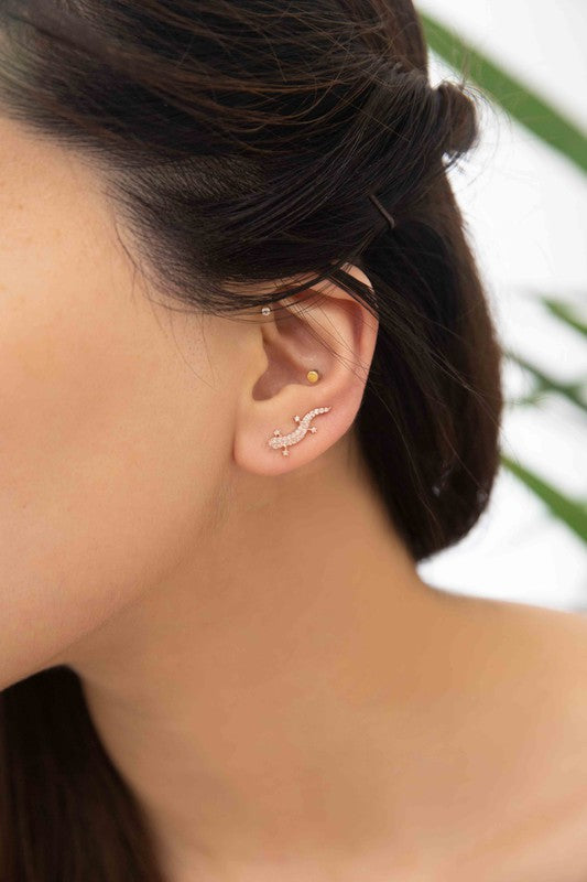 Three pairs of Lizard Ear Pin Earrings, featuring captivating stone-studded designs in gold, rose gold, and silver-plated brass jewelry, are elegantly presented on a light surface.