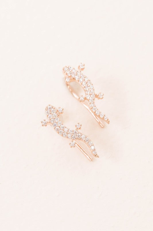 Three pairs of Lizard Ear Pin Earrings, featuring captivating stone-studded designs in gold, rose gold, and silver-plated brass jewelry, are elegantly presented on a light surface.