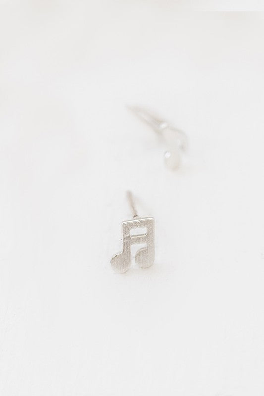 The Musical Note Earrings, crafted from sterling silver and shaped like musical notes, are set against a white background. These asymmetrical earrings are an ideal choice for music enthusiasts wanting to infuse their style with a hint of melody.