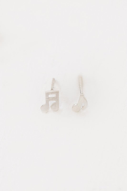 The Musical Note Earrings, crafted from sterling silver and shaped like musical notes, are set against a white background. These asymmetrical earrings are an ideal choice for music enthusiasts wanting to infuse their style with a hint of melody.