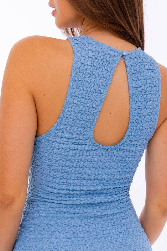 A woman in a stylish Textured Fabric Laser Dress featuring a keyhole back.