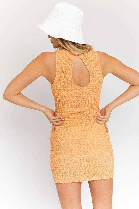 A woman in a stylish Textured Fabric Laser Dress featuring a keyhole back.