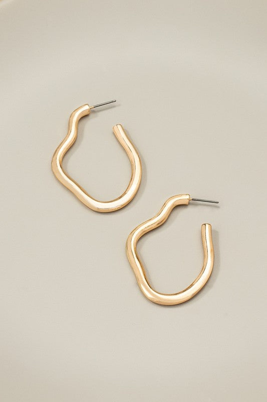 The Irregular shape metal hoop earrings, featuring a shiny gold finish and post back closures, are displayed on a neutral background.